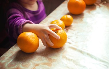 Çocuk ve mandalina. Seçici odak. 