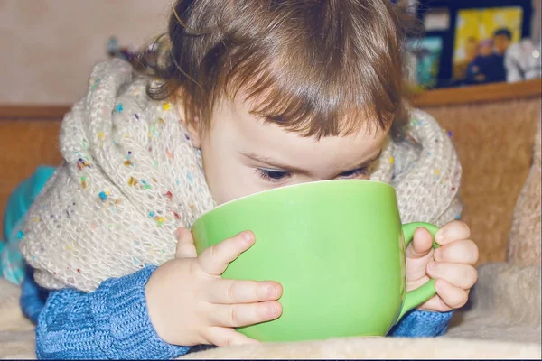 The child is sick and drinks a lot of tea. Selective focus.