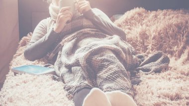 Naya bir fincan bir kızla bir battaniyenin altında yatıyor. Rekreasyon. Seçici odak. 