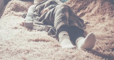 Naya bir fincan bir kızla bir battaniyenin altında yatıyor. Rekreasyon. Seçici odak. 