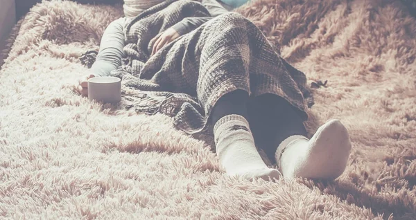 Naya bir fincan bir kızla bir battaniyenin altında yatıyor. Rekreasyon. Seçici odak. 