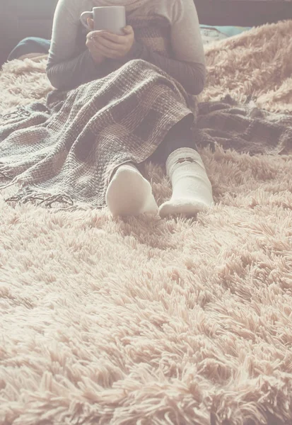 Naya bir fincan bir kızla bir battaniyenin altında yatıyor. Rekreasyon. Seçici odak. 