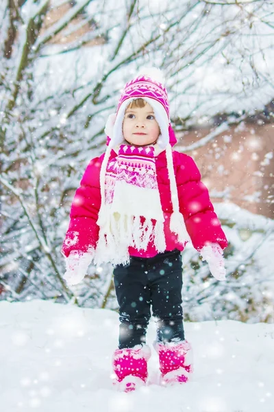 Barn leker i snön på vintern. Selektivt fokus. — Stockfoto