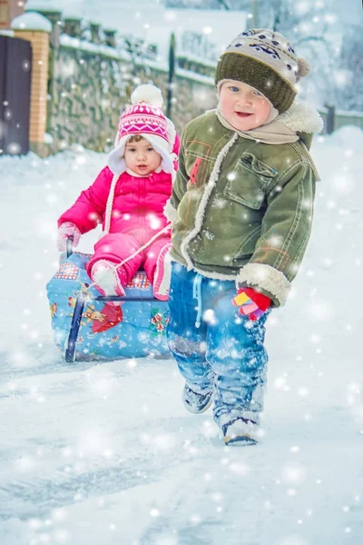 Barn leker i snön på vintern. Selektivt fokus. — Stockfoto