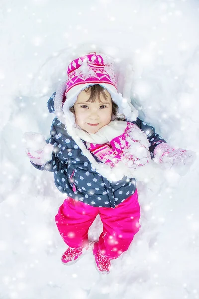 Dítě hraje na sněhu v zimě. Selektivní fokus. — Stock fotografie
