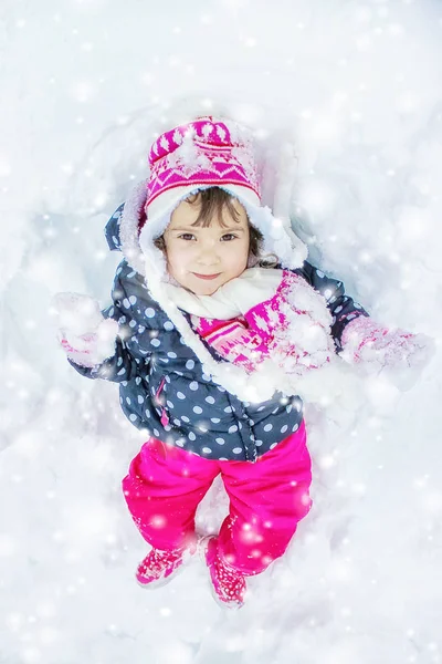 Un enfant joue dans la neige en hiver. Concentration sélective . — Photo