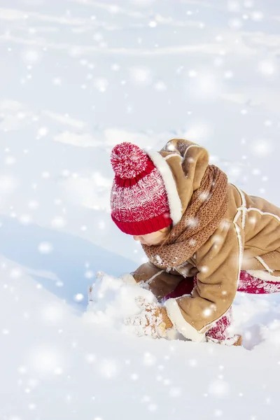 A gyermek játszik a hó a téli hónapokban. Szelektív összpontosít. — Stock Fotó
