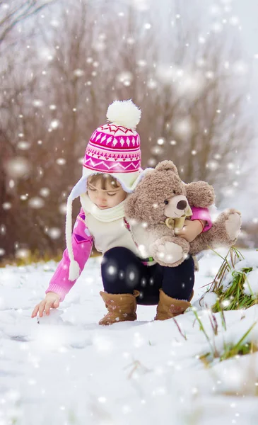 Dziecko odgrywa w śniegu w zimie. Selektywny fokus. — Zdjęcie stockowe