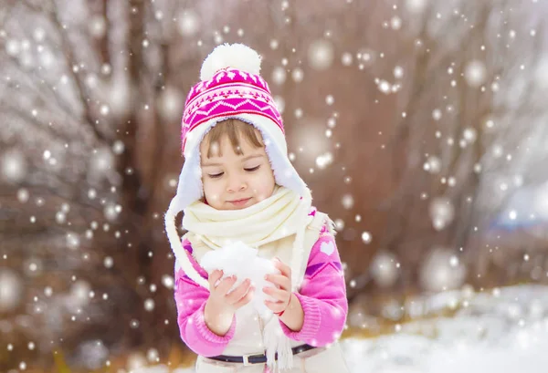Barn leker i snön på vintern. Selektivt fokus. — Stockfoto
