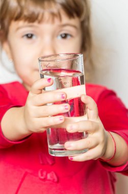 Bir çocuk bir bardak su tutuyor. Seçici odak. 