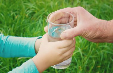 Çocuk bir bardak su alır. Seçici odak. 