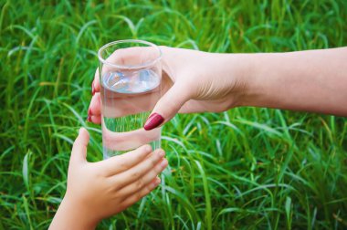 Çocuk bir bardak su alır. Seçici odak. 