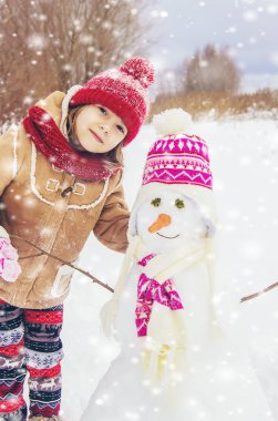 Kış çocuk içinde belgili tanımlık kar. Bir kardan adam yapmak için. Seçici odak.