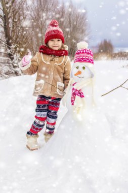 Kış çocuk içinde belgili tanımlık kar. Bir kardan adam yapmak için. Seçici odak.