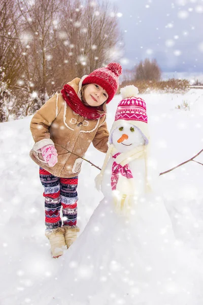 冬天的孩子在雪地里 做一个雪人 选择性焦点 — 图库照片