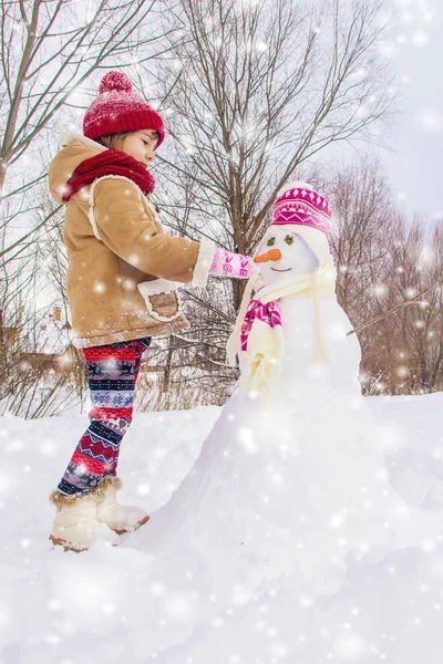 冬天的孩子在雪地里 做一个雪人 选择性焦点 — 图库照片