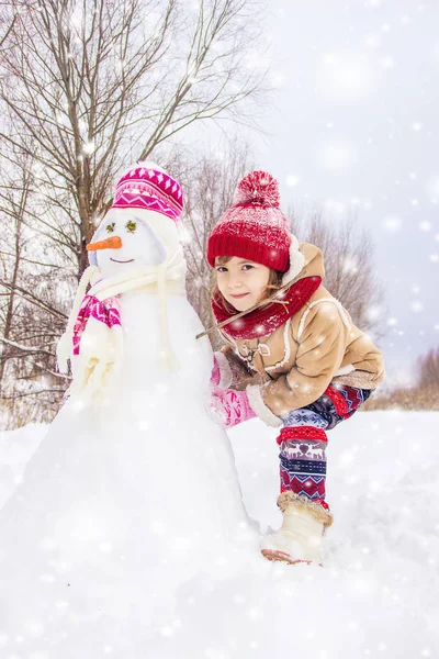 冬天的孩子在雪地里 做一个雪人 选择性焦点 — 图库照片