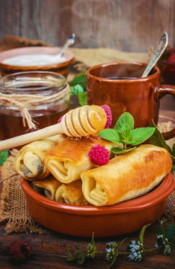 Krep ve çay bir ahşap zemin üzerinde. Seçici odak.