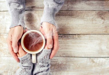 Bir fincan çay bir erkek ve bir kadın elinde. Seçici odak.