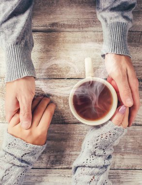 Bir fincan çay bir erkek ve bir kadın elinde. Seçici odak.