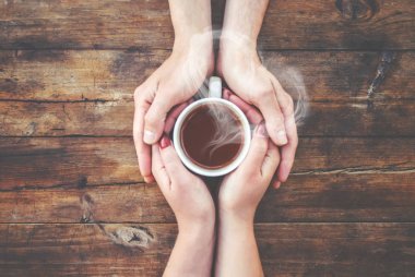 Bir fincan çay bir erkek ve bir kadın elinde. Seçici odak.