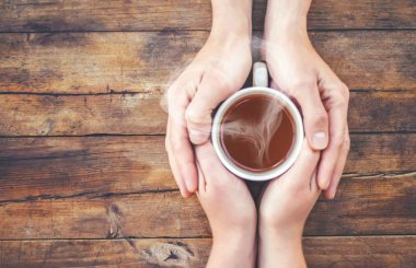 Bir fincan çay bir erkek ve bir kadın elinde. Seçici odak.