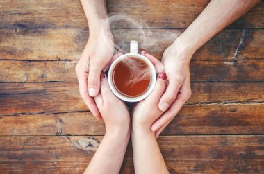 Bir fincan çay bir erkek ve bir kadın elinde. Seçici odak.