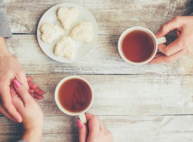 Bir fincan çay bir erkek ve bir kadın elinde. Seçici odak.