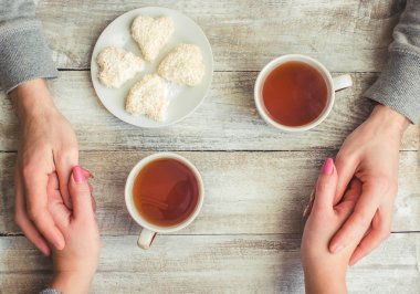 Bir fincan çay bir erkek ve bir kadın elinde. Seçici odak.