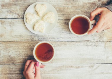 Bir fincan çay bir erkek ve bir kadın elinde. Seçici odak.