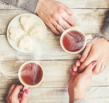 Bir fincan çay bir erkek ve bir kadın elinde. Seçici odak.