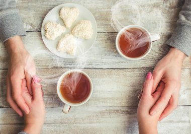 Bir fincan çay bir erkek ve bir kadın elinde. Seçici odak.