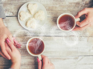 Bir fincan çay bir erkek ve bir kadın elinde. Seçici odak.