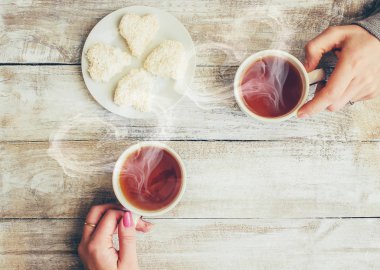 Bir fincan çay bir erkek ve bir kadın elinde. Seçici odak.