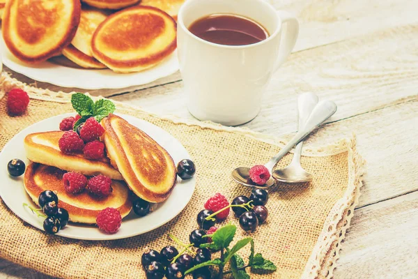 Pancakes for tea with honey and berries. Selective focus.