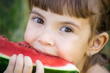 Bir çocuk karpuz yiyor. Seçici odak.