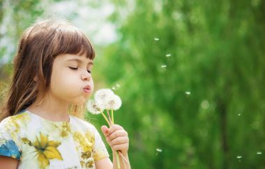 Dandelions hava üfleme kız. seçici odak.