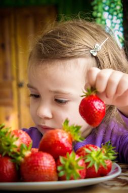 Çocuk ve çilek. Seçici odak.