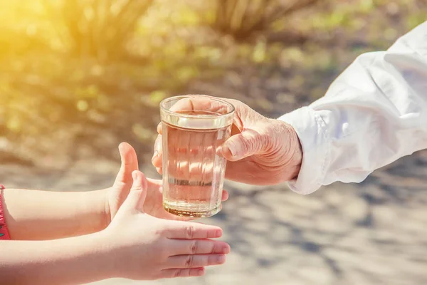Mormor Ger Ett Glas Rent Vatten Till Ett Barn Selektiv — Stockfoto