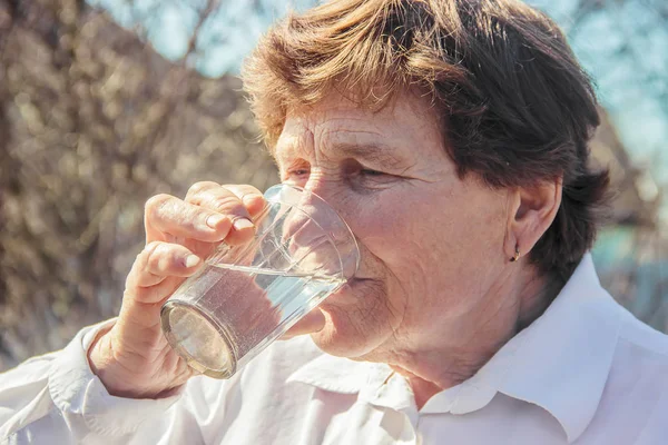 Een Oude Vrouw Drinkt Water Selectieve Aandacht — Stockfoto