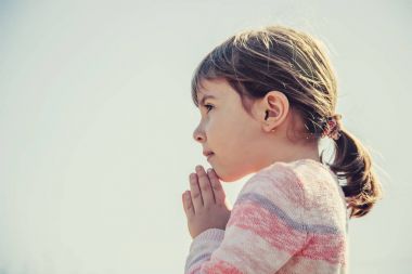 Çocuk Tanrı'ya dua ediyor. Seçici odak.