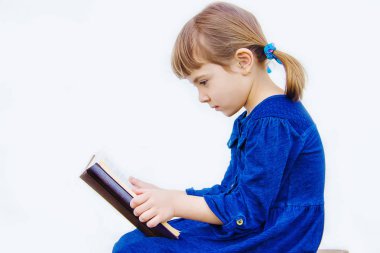 Çocuk bir kitap okuyor. Seçici odak. 