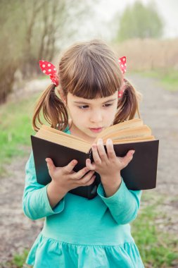 Çocuk bir kitap okuyor. Seçici odak. 