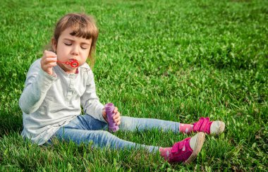 Bir çocuk yaz çimenlerin üzerinde yer almaktadır. Seçici odak.