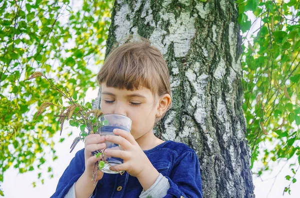 birch sap in the hands of a child. Selective focus.