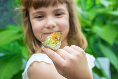 Çocuk ile bir kelebek. Seçici odak.