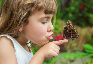 Çocuk ile bir kelebek. Seçici odak.