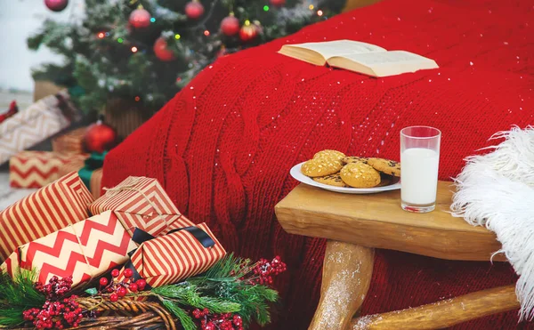 Fotolibro de Navidad con galletas y un vaso de leche en la cama. Enfoque selectivo . — Foto de Stock