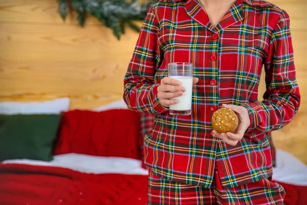 Mañana de Navidad, niña en pijama con galletas y un vaso de leche. Enfoque selectivo . —  Fotos de Stock