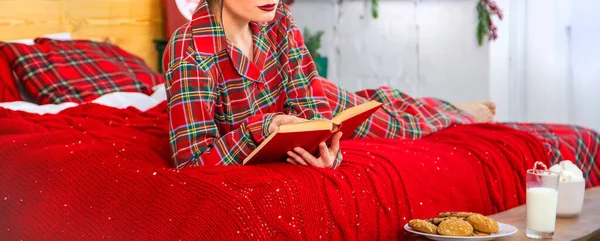 Świąteczny poranek, dziewczyna w piżamie z książką. Skupienie selektywne. — Zdjęcie stockowe